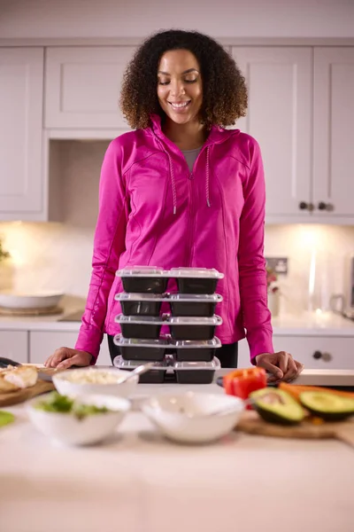 厨房里的女人穿着合身的衣服 预先为冰箱准备了一批批健康的饭菜 — 图库照片