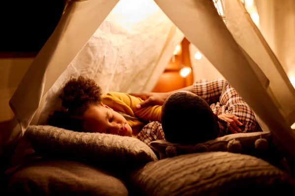 Father And Daughter At Home Sleeping In Indoor Tent Or Camp