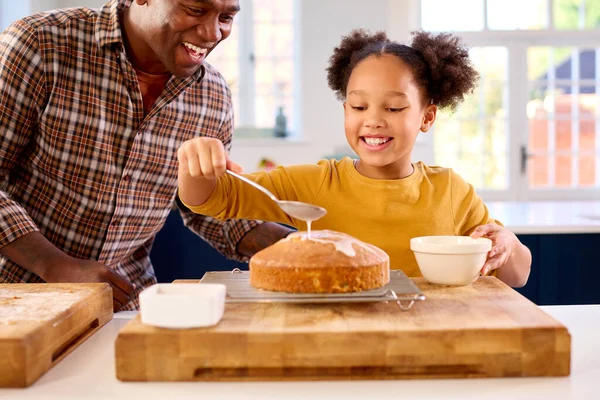 Baba Kızıyla Birlikte Mutfakta Pasta Pişirirken Çekilmiş Dondurmayla Süslenmiş Pasta — Stok fotoğraf