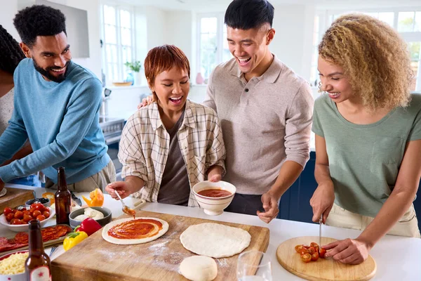 Gruppo Amici Casa Cucina Che Aggiungono Salsa Alle Pizze Fatte — Foto Stock