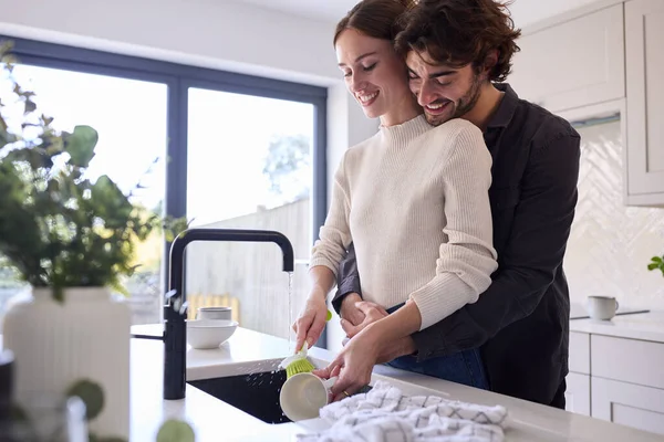 Casal Abraçando Casa Cozinha Como Mulher Faz Lavar — Fotografia de Stock