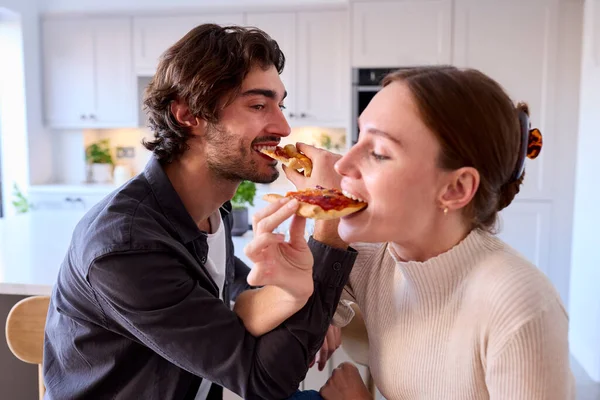 Para Kuchni Domu Łączenie Ramiona Jedzenia Domowej Pizzy Siedząc Liczniku — Zdjęcie stockowe
