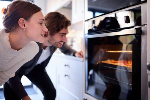Ζευγάρι Στην Κουζίνα Στο Σπίτι Βλέποντας Σπιτική Πίτσα Στο Φούρνο — Φωτογραφία Αρχείου