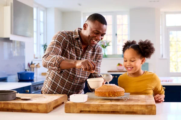 在厨房里和父亲一起射击 女儿在家里烘焙 用冰棍点缀蛋糕 — 图库照片