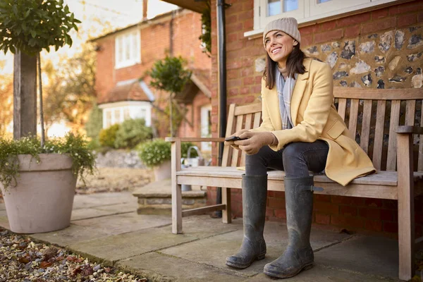 Woman Sitting Bench Home Wearing Boots Holding Mobile Phone Ready — Stock Photo, Image