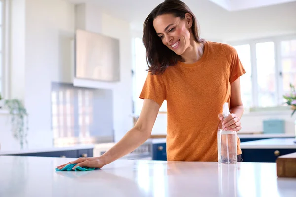 自宅でキッチンで家事をする女掃除とスプレーで表面を消毒 — ストック写真