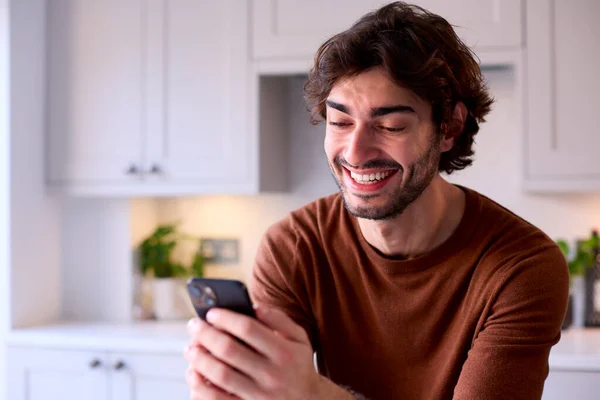 Mutfakta Dinlenen Genç Adam Cep Telefonundan Sosyal Medyayı Kontrol Ediyor — Stok fotoğraf