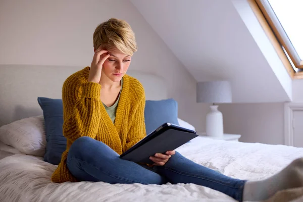 Mujer Joven Preocupada Sentada Cama Casa Mirando Tableta Digital — Foto de Stock