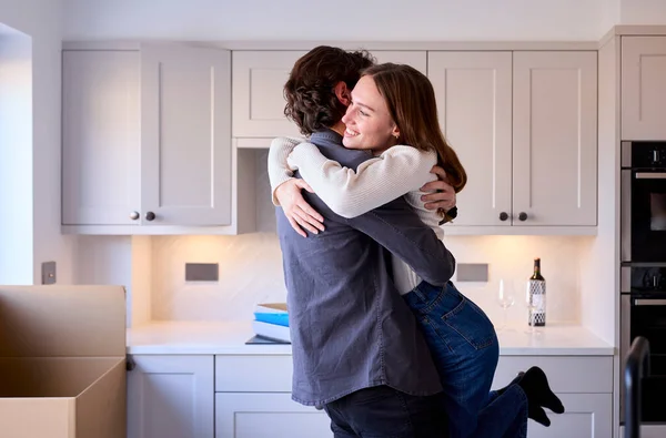 Young Couple Moving New Home Hugging Unpack Boxes Kitchen Together — Stock Photo, Image