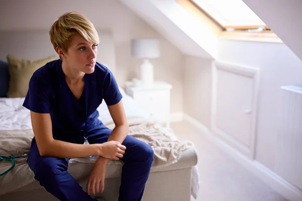 Bedachtzame Vrouw Draagt Medische Scrubs Zittend Bed Thuis — Stockfoto