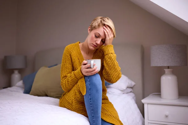 Olycklig Ung Kvinna Med Varm Dryck Sitter Sängen Hemma — Stockfoto
