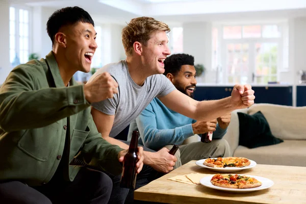 一群兴奋的男性朋友一起在家中看电视 一起吃比萨饼 — 图库照片