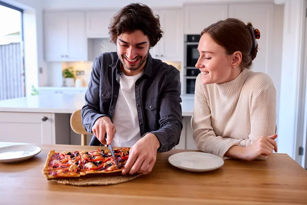 Para Kuchni Domu Cięcia Jedzenia Pizzy Domowej Roboty Siedzi Przy — Zdjęcie stockowe