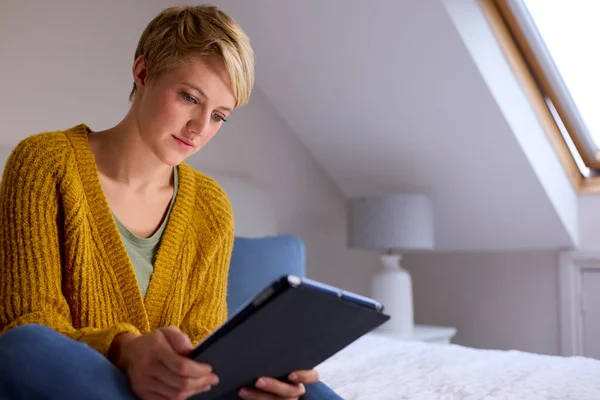 Młoda Kobieta Siedzi Łóżku Domu Patrząc Cyfrowy Tablet — Zdjęcie stockowe