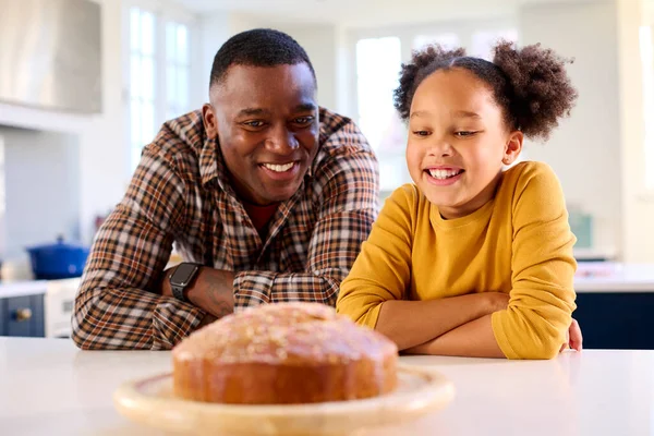 自慢の父と娘がキッチンで一緒に焼いた自家製ケーキを見る — ストック写真