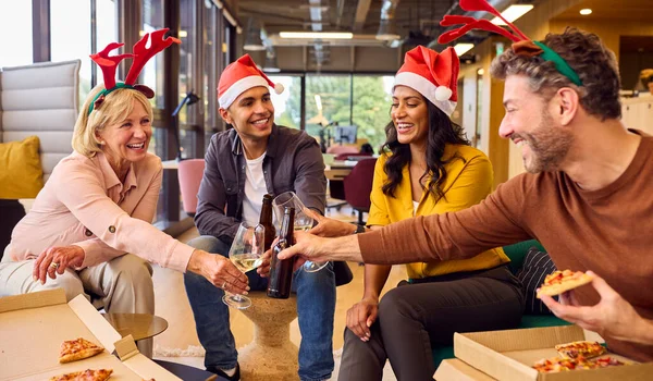 クリスマスパーティーでのスタッフのお祝いオフィスでの食事と飲み物 — ストック写真