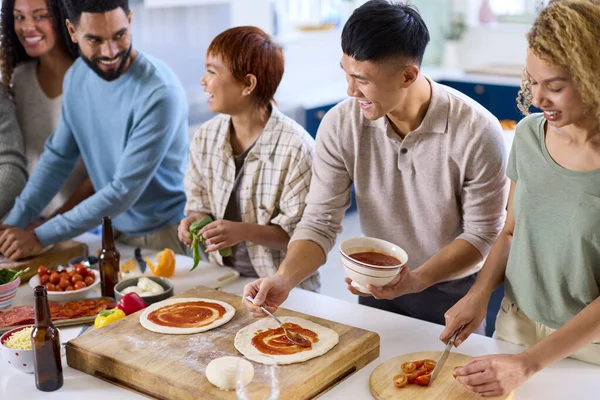 Grupa Przyjaciół Domu Kuchni Dokonywanie Pizzy Imprezę Razem — Zdjęcie stockowe