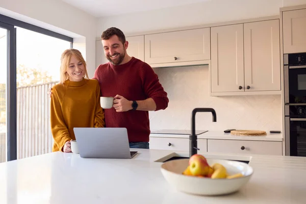 Evdeki Çift Mutfaktaki Bilgisayara Birlikte Bakıyor — Stok fotoğraf