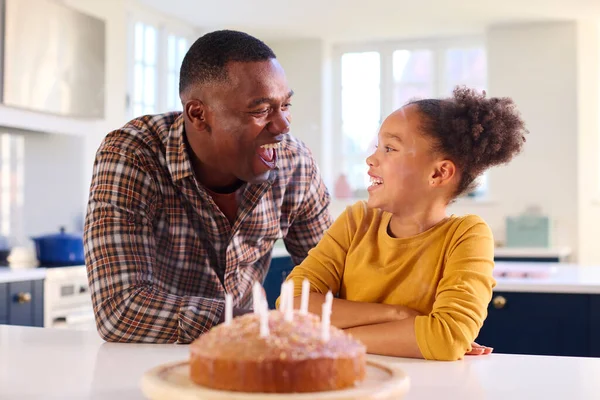 Ojciec Córka Domu Kuchni Świętując Zdmuchnięcie Świeczek Domowe Ciasto Urodzinowe — Zdjęcie stockowe