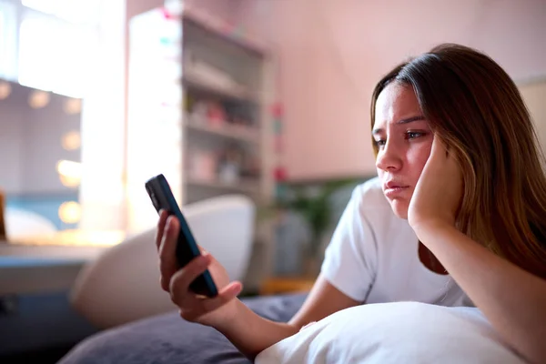 Deprimido Adolescente Menina Deitada Cama Casa Olhando Para Telefone Móvel — Fotografia de Stock
