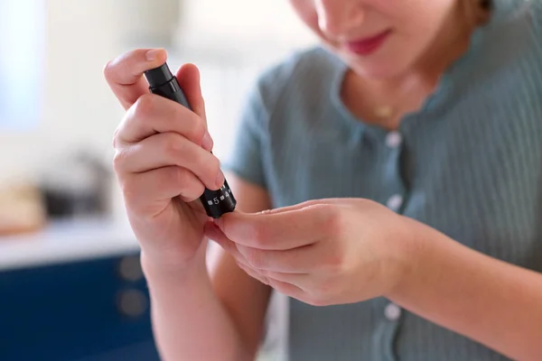 부엌에서 모니터 키트를 사용하여 포도당 농도를 측정하기 에서의 당뇨병 소녀의 — 스톡 사진