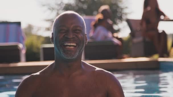 夏休みや休暇中の老人の肖像プールの端に立って カメラに笑みを浮かべて スローモーションで撮影 — ストック動画