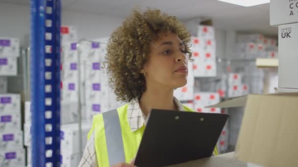 デジタルタブレットを使用して物流倉庫チェック在庫の女性労働者 スローモーションで撮影 — ストック動画