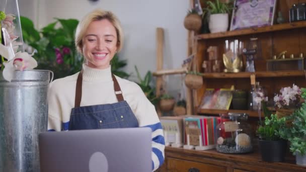 Çiçekçi Dükkanının Kadın Sahibi Video Sohbeti Için Dizüstü Bilgisayar Kullanıyor — Stok video