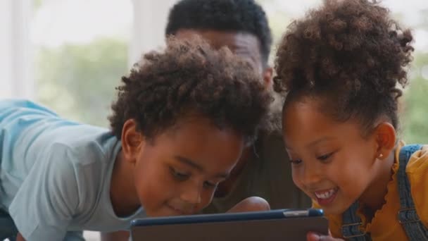 爸爸在家里的孩子们躺在地毯上玩着数字平板电脑 动作缓慢 — 图库视频影像