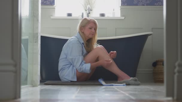 月经成熟妇女 尿失禁时坐在浴室的地板上 手持尿失禁垫 慢动作射击 — 图库视频影像