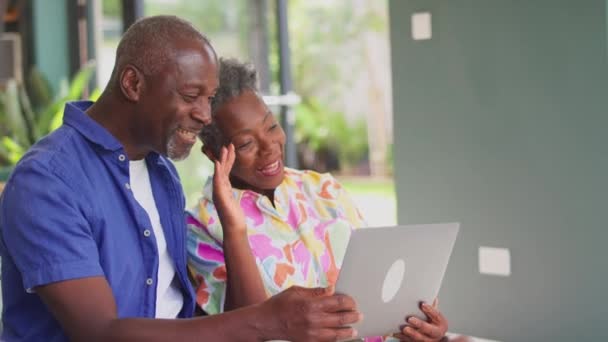 Evde Gülümseyen Yaşlı Çift Dizüstü Bilgisayardan Aileleriyle Video Bağlantısı Kuruyor — Stok video