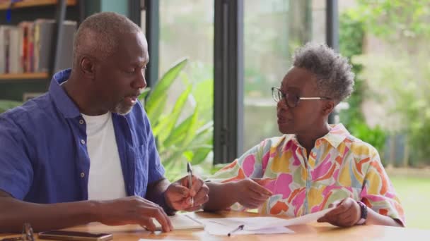 一对年长的夫妇坐在家里的桌子旁 手里拿着审查家庭财政的法案 动作缓慢 — 图库视频影像