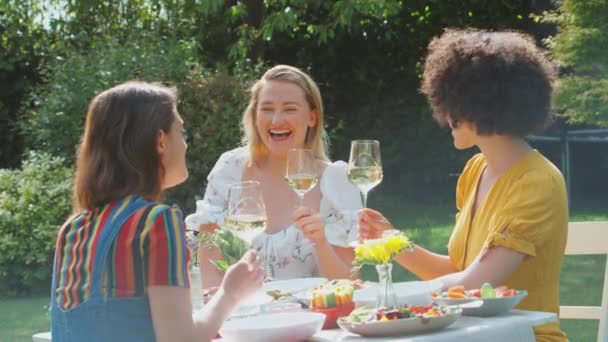 三个女性朋友坐在夏天的花园里 一边吃饭 一边喝酒 一边聊天 动作缓慢 — 图库视频影像