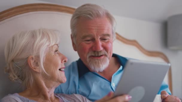 Glimlach Gepensioneerd Senior Paar Bed Thuis Kijken Naar Digitale Tablet — Stockvideo