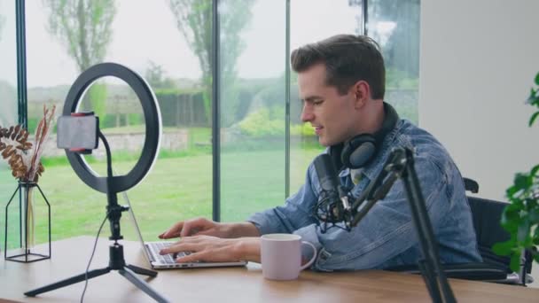 Мужчина Видеоблоггер Наушниках Печатающих Ноутбуке Перед Прямой Трансляцией Снят Замедленной — стоковое видео