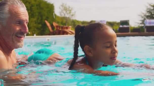 Rodzice Uczący Córkę Pływać Odkrytym Basenie Rodzinne Wakacje Nakręcony Zwolnionym — Wideo stockowe