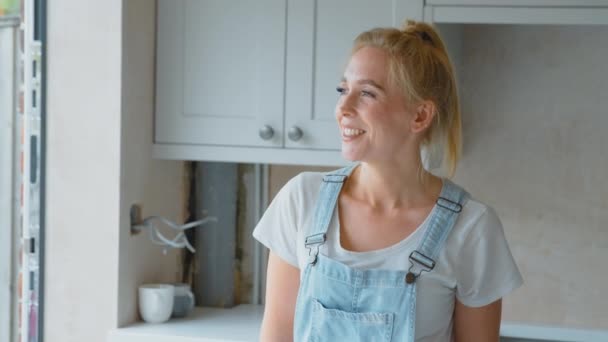 笑顔の女性の肖像画は自宅で台所を改装服を着て スローモーションで撮影 — ストック動画