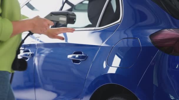 Garajdaki Kadının Elektrik Kablosunu Ağır Çekimde Çekilen Elektrikli Arabaya Bağladığı — Stok video