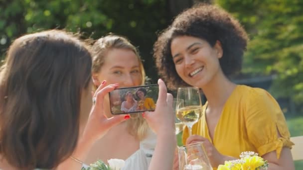 Mujer Tomando Vídeo Teléfono Móvil Amigos Sentados Jardín Verano Bebiendo — Vídeos de Stock