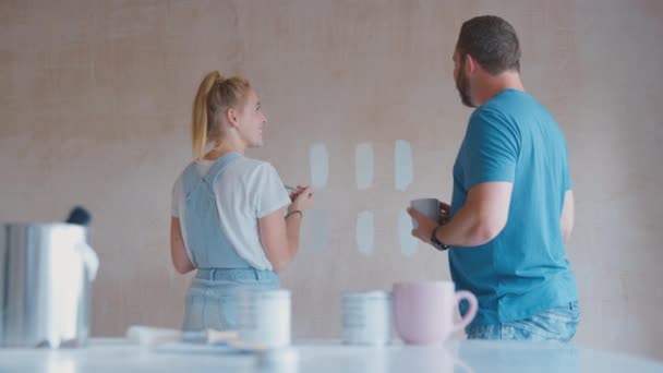 夫婦は 家庭用塗装テスターでキッチンを改装石膏壁にカラーストリップをペイント スローモーションで撮影 — ストック動画