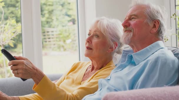 Gepensioneerd Senior Paar Zit Bank Lounge Thuis Samen Met Afstandsbediening — Stockvideo