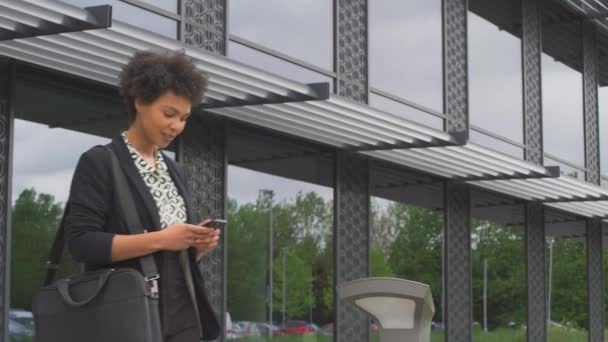 Modern Ofis Binasının Dışındaki Kadını Yürürken Cep Telefonuna Bakıyor Ağır — Stok video