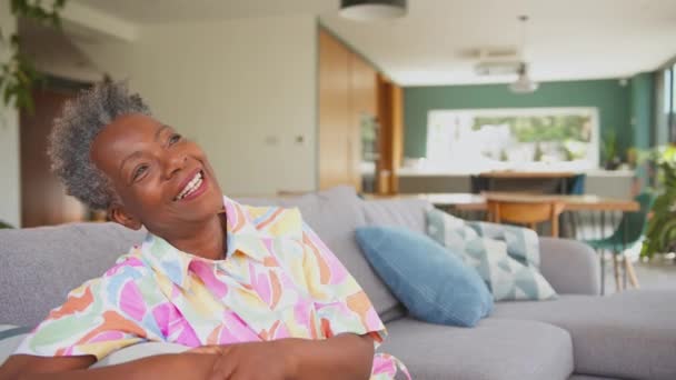 Porträt Einer Seniorin Die Lächelnd Und Lachend Auf Dem Sofa — Stockvideo