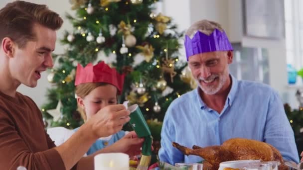 Wielopokoleniowa Rodzina Świętująca Boże Narodzenie Domu Zakładająca Kapelusze Krakersów Przed — Wideo stockowe