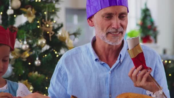 Mehrgenerationenfamilie Feiert Weihnachten Hause Und Setzt Sich Vor Dem Gemeinsamen — Stockvideo