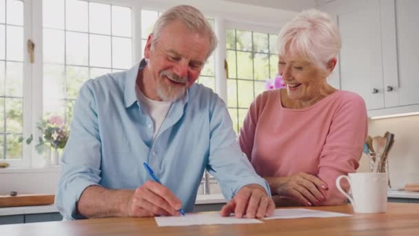 Glimlach Gepensioneerd Senior Paar Thuis Keuken Ondertekenen Juridische Financiële Document — Stockvideo