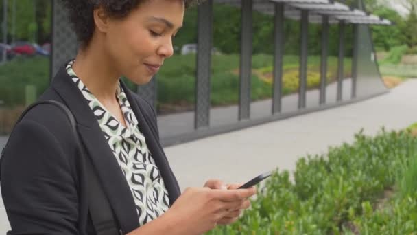 Modern Ofis Binasının Dışındaki Kadını Yürürken Cep Telefonundan Mesaj Gönderiyor — Stok video
