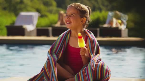 Mädchen Handtuch Gehüllt Sitzt Sommerurlaub Pool Und Isst Eis Aufgenommen — Stockvideo