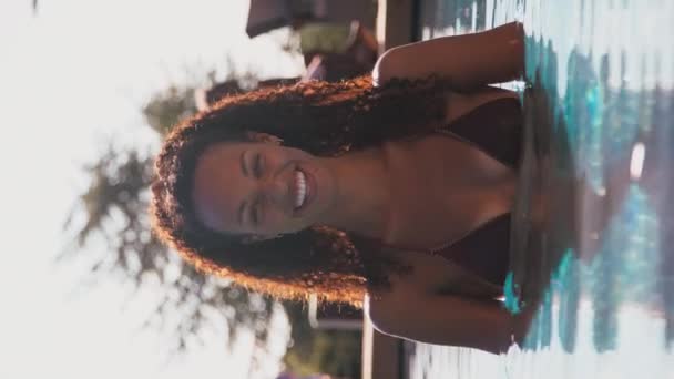 夏休みや休暇中の女性の垂直ビデオプールの端に立って カメラに笑みを浮かべて スローモーションで撮影 — ストック動画