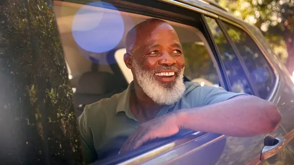 Glimlachende Senior Mannelijke Passagier Kijken Uit Van Achter Stoel Auto — Stockfoto